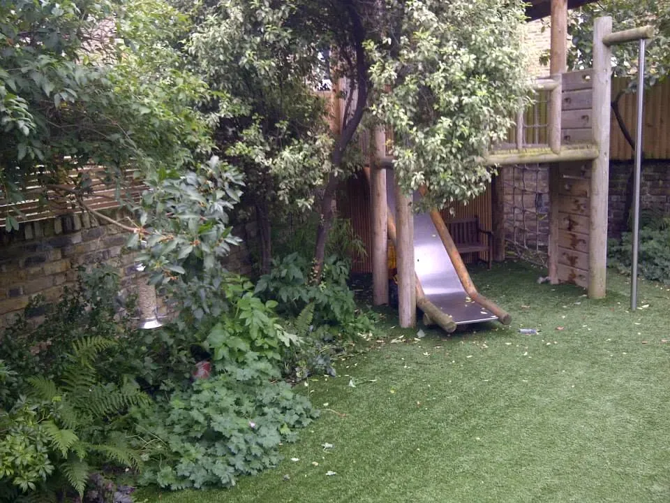 An established garden beside a lawn and play area